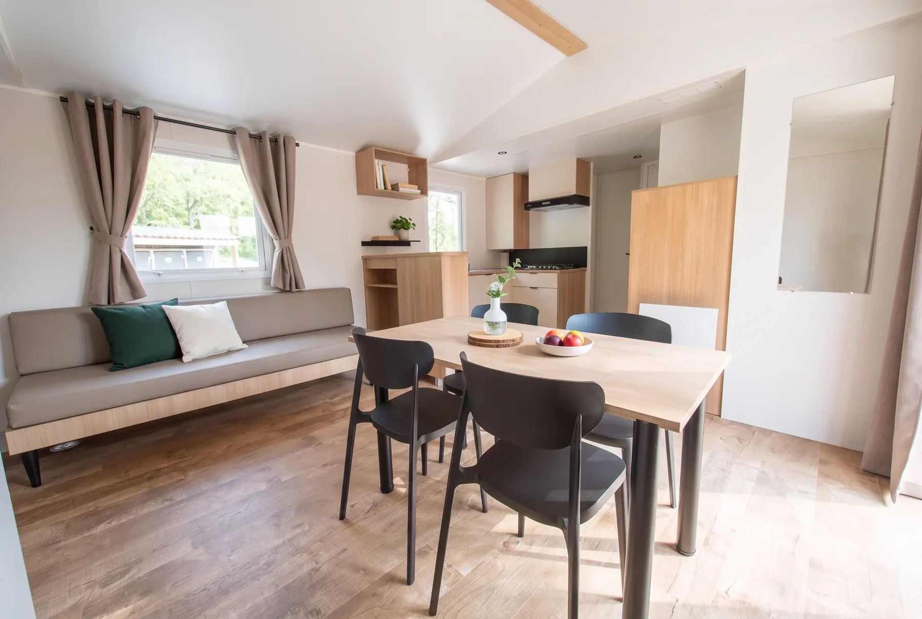 Le séjour d’un NEST 40.3 : banquette, table de repas et cuisine ouverte
